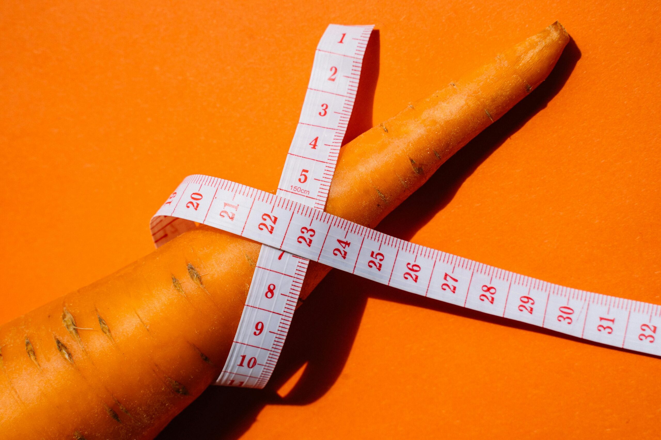 diäten im fokus: überblick über möglichkeiten und herausforderungen 4 weißes maßband auf orangefarbenem textil